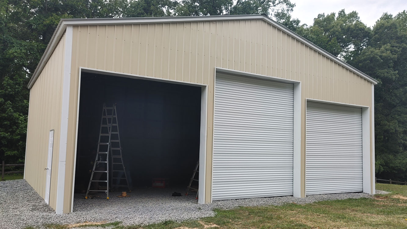 40' wide, 40' long, 15' tall Light Stone metal garage with Black vertical metal roof and Light Stone vertical metal siding, anchored to gravel pad